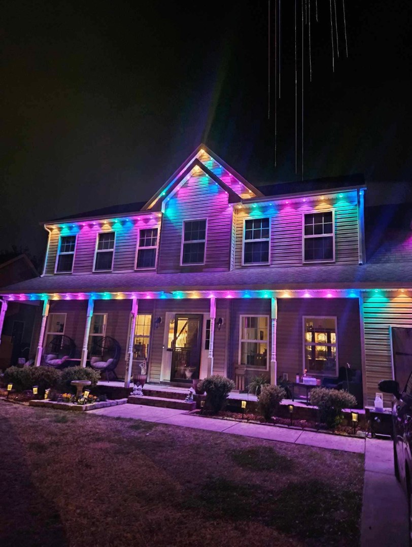 Two-story home at night with permanent color-changing LED lights on every roofline